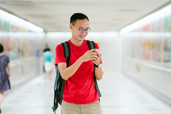 Male student smiling and looking at his phone