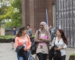 Smiling students walking through Southampton campus